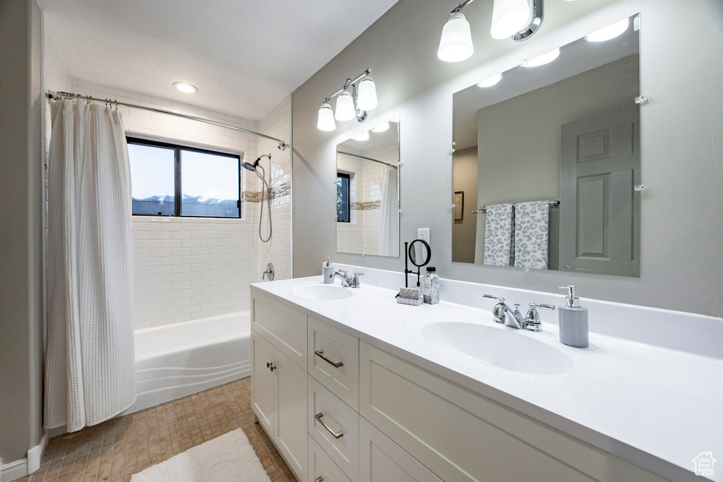 Full bath with shower / bath combo with shower curtain and double vanity