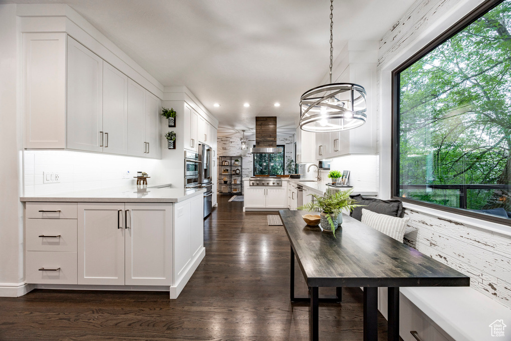Kitchen featuring tasteful backsplash, a peninsula, stainless steel appliances, extractor fan, and recessed lighting