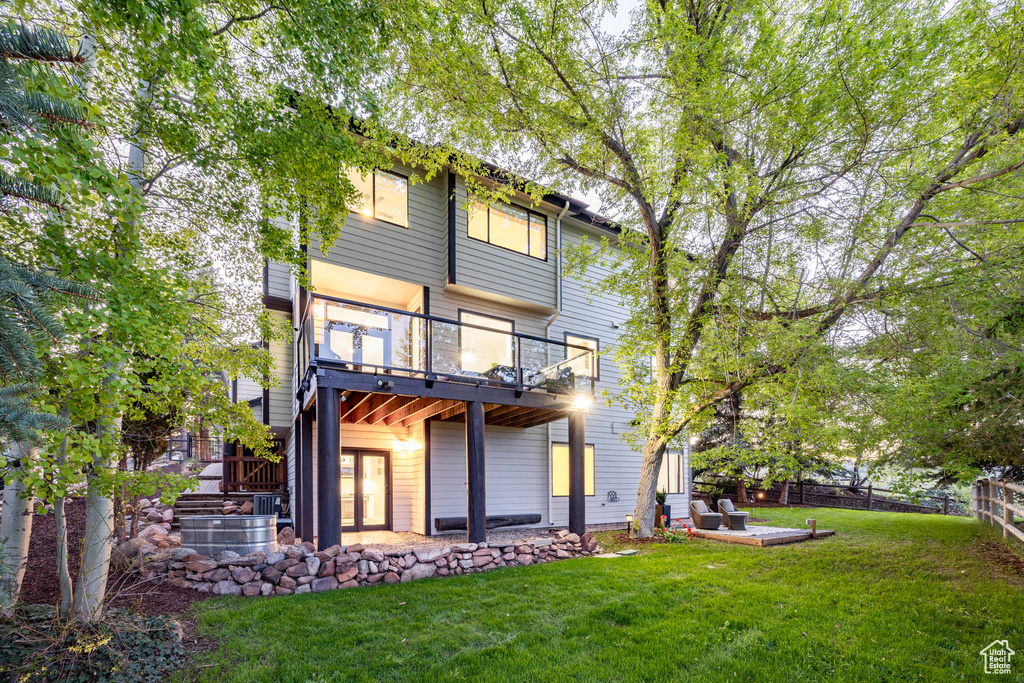 Rear view of house with a patio and a balcony