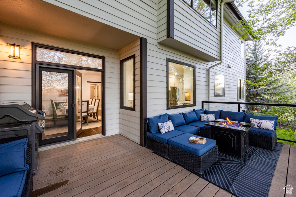 Wooden deck featuring an outdoor living space with a fire pit and a grill