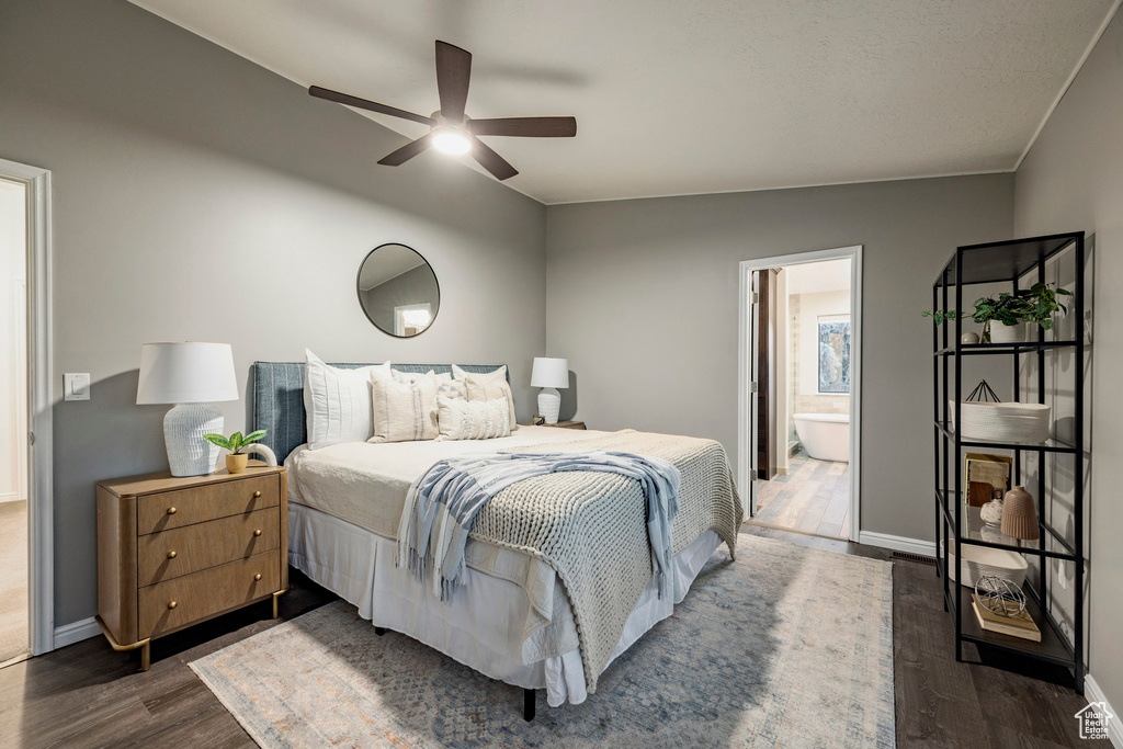 Bedroom with dark wood finished floors, baseboards, ensuite bathroom, and a ceiling fan