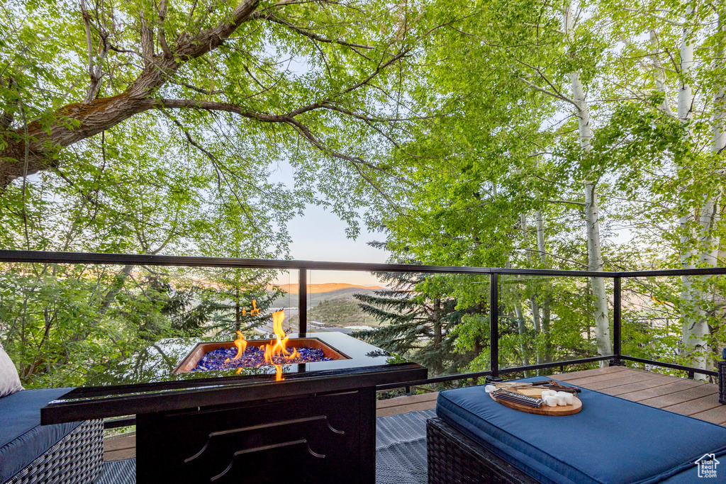 View of wooden balcony with a fire pit and a wooden deck
