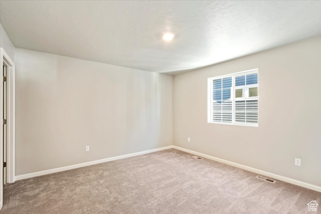 Carpeted spare room with baseboards