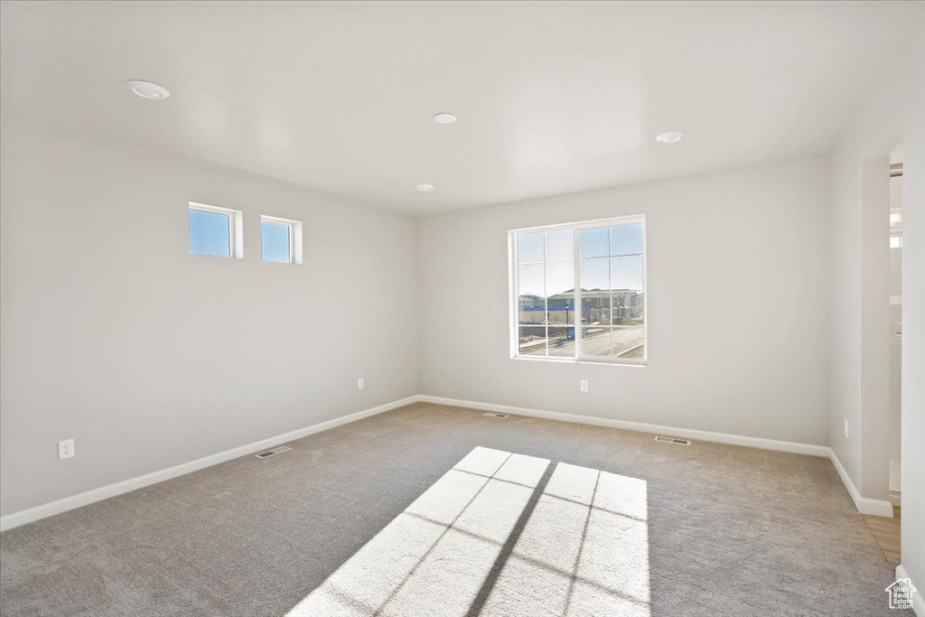 Carpeted empty room featuring healthy amount of natural light, baseboards, and recessed lighting