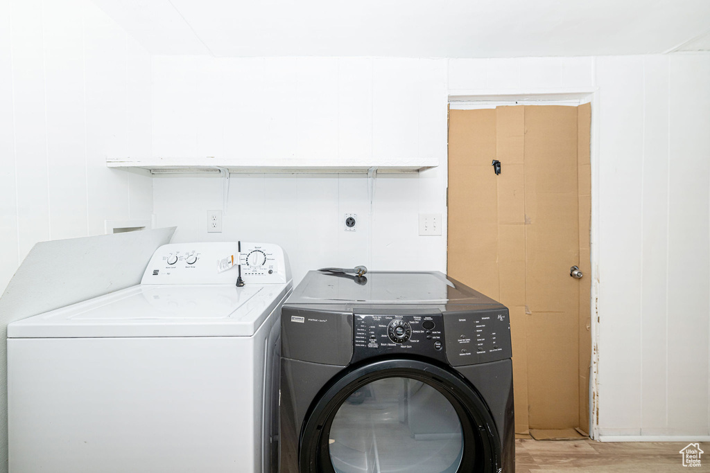Washroom with washer and dryer and light wood-style flooring