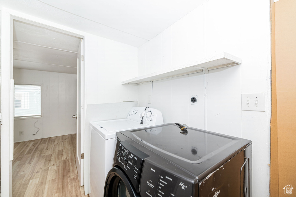 Washroom featuring washer and clothes dryer and light wood finished floors