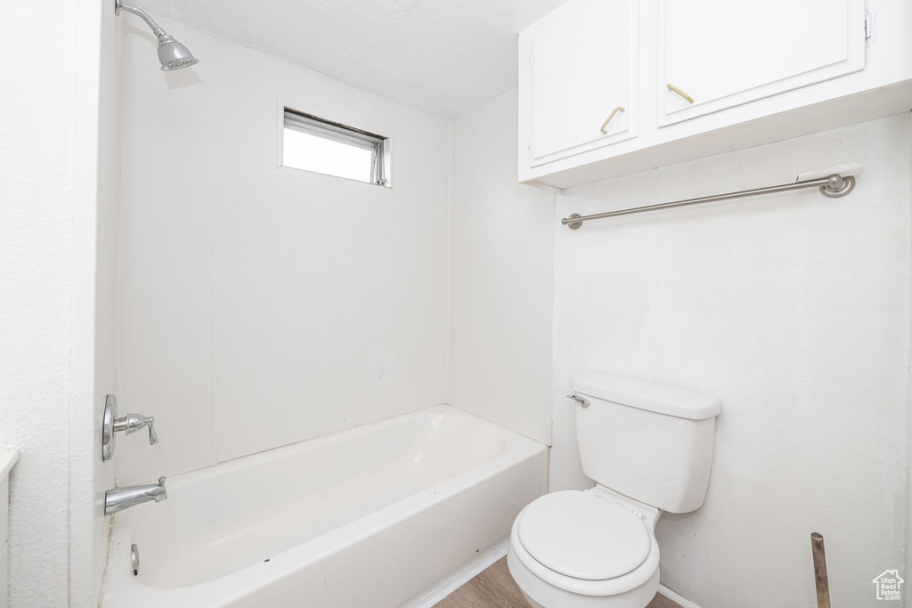 Full bath featuring toilet and bathing tub / shower combination