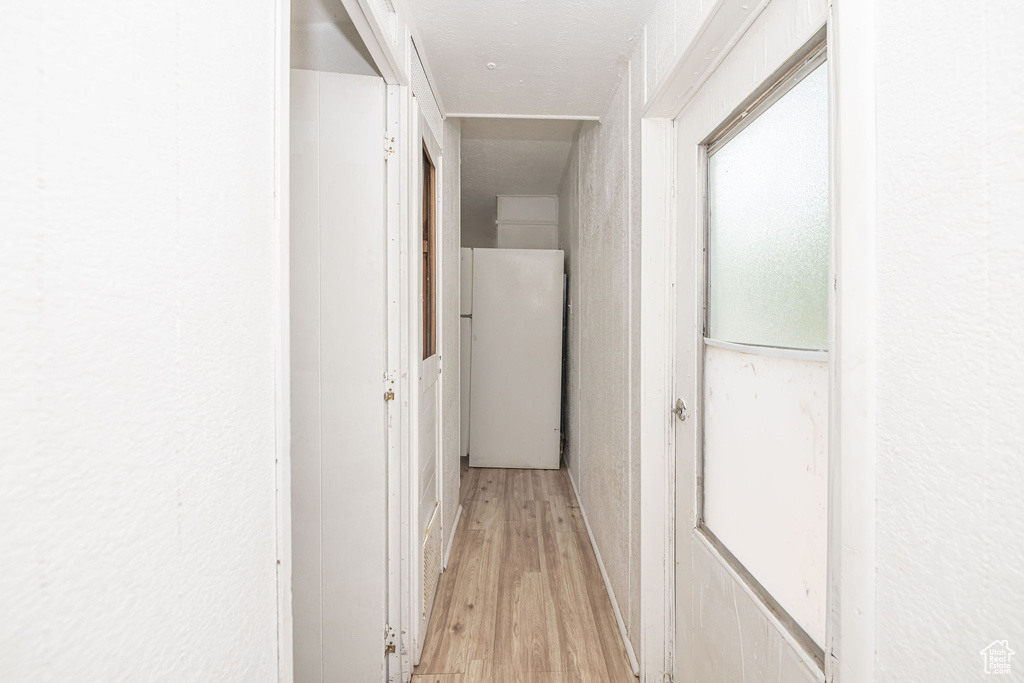 Corridor featuring light wood-style flooring