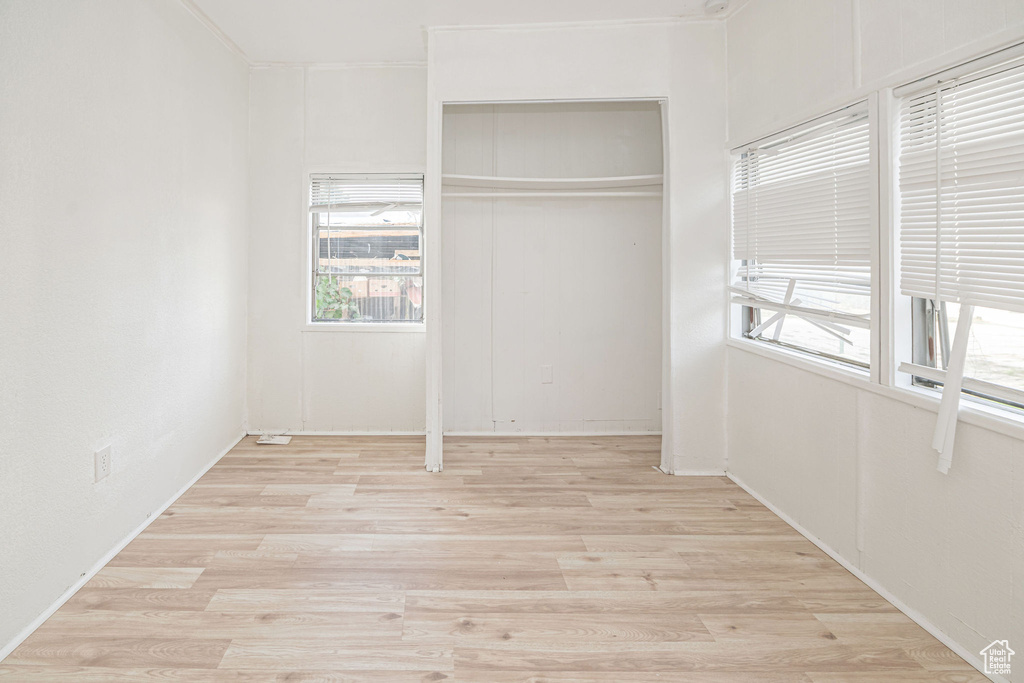 Unfurnished bedroom featuring light wood-style floors and a closet