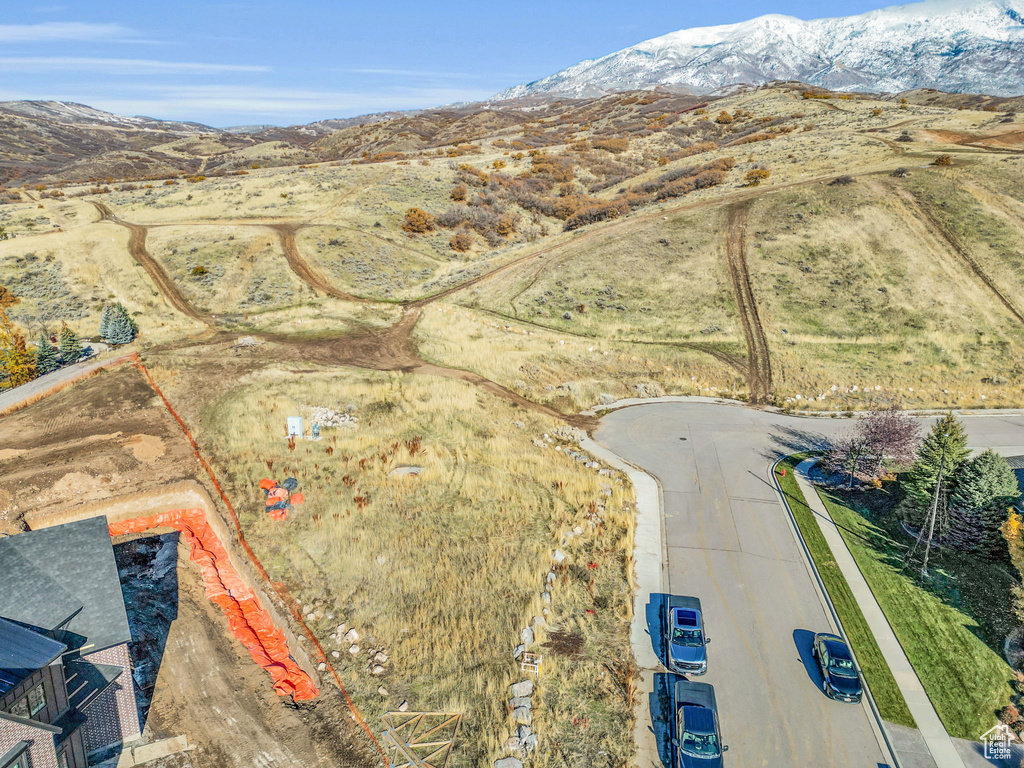 Aerial view of property and surrounding area with a mountain backdrop and property parcel outlined