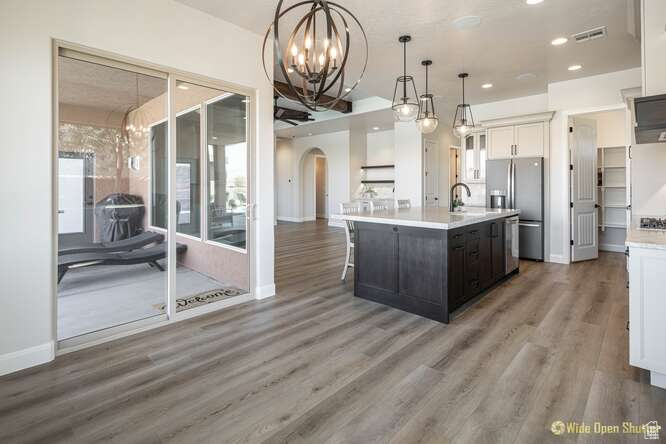 Kitchen with arched walkways, stainless steel appliances, a chandelier, light countertops, and recessed lighting