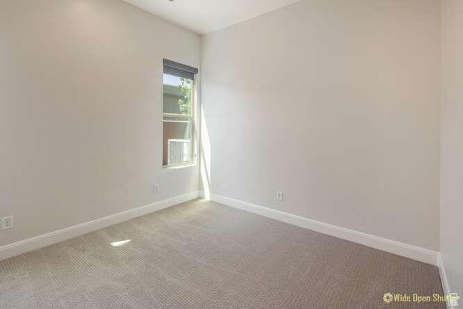 Carpeted empty room featuring baseboards