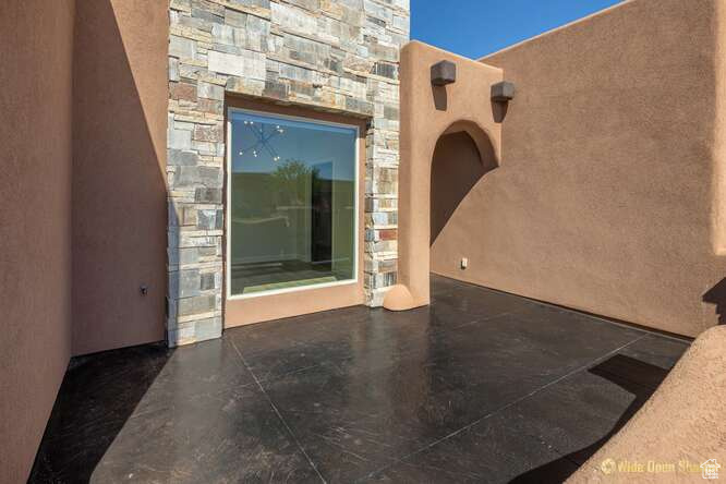 View of exterior entry with stone siding and stucco siding