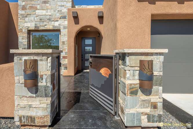 Property entrance featuring stone siding and stucco siding
