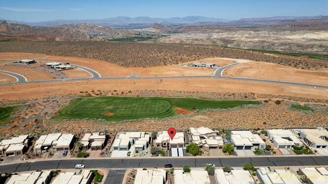 Aerial overview of property\'s location featuring mountains, nearby suburban area, and a golf club