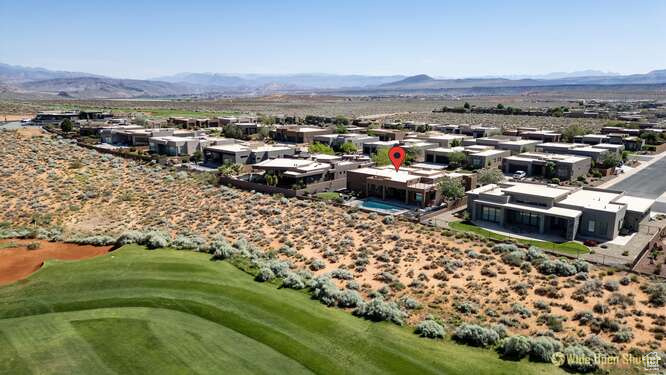Drone / aerial view of a mountain backdrop and a golf club