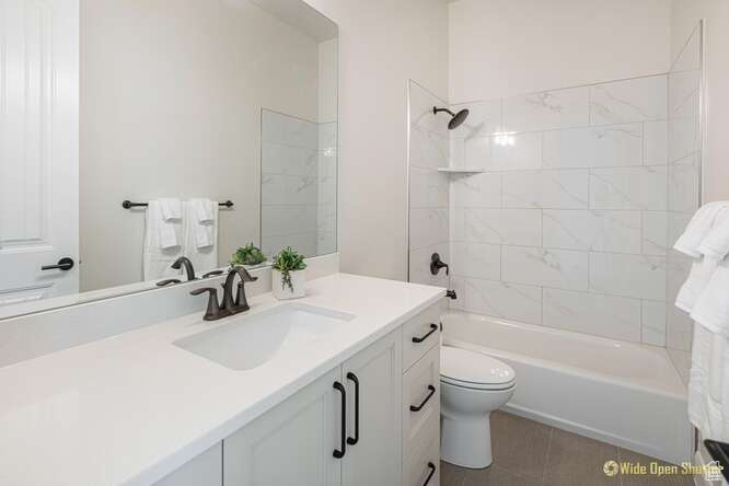 Full bath with toilet, vanity, shower / washtub combination, and tile patterned flooring