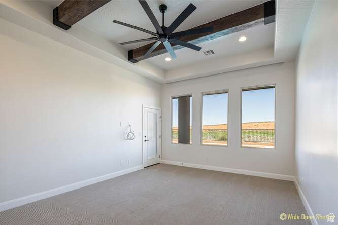 Unfurnished room with beamed ceiling, carpet flooring, a ceiling fan, baseboards, and recessed lighting