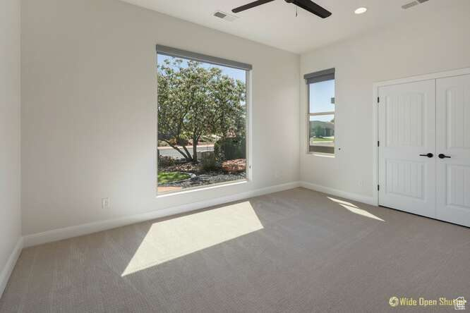 Carpeted empty room featuring a ceiling fan, baseboards, and recessed lighting