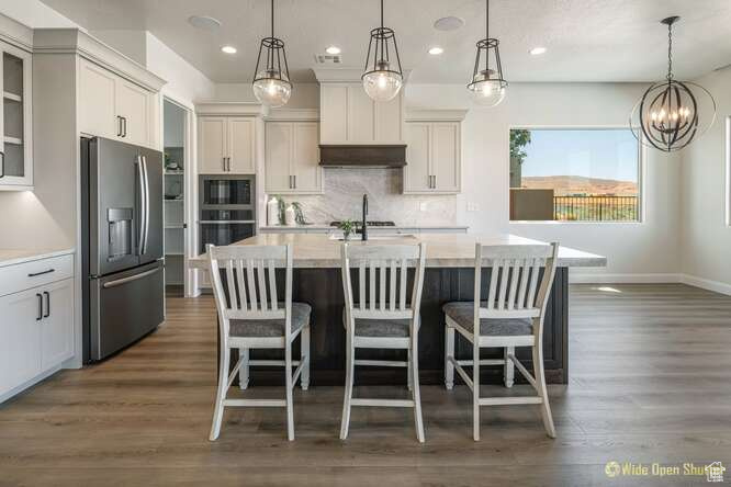 Kitchen featuring appliances with stainless steel finishes, recessed lighting, light countertops, decorative backsplash, and dark wood finished floors