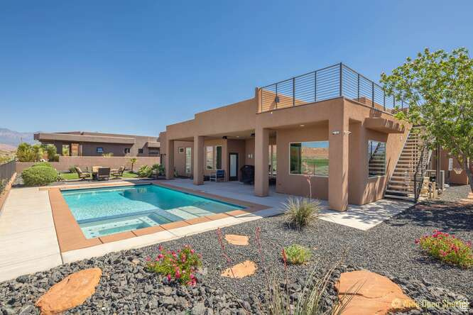 View of pool featuring a patio, a fenced backyard, stairway, and a pool with connected hot tub