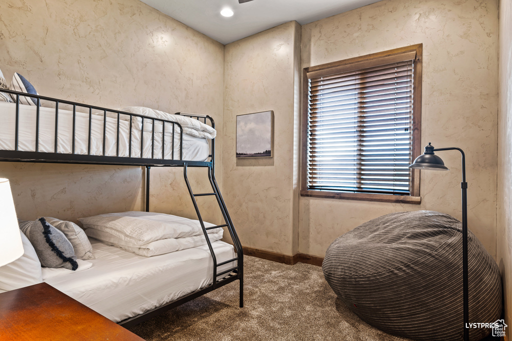 Carpeted bedroom with a textured wall and baseboards