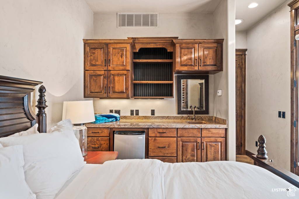 Kitchen featuring refrigerator, open shelves, a sink, brown cabinetry, and recessed lighting
