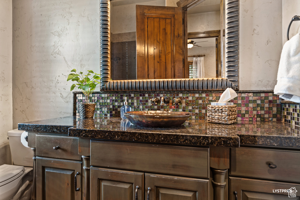 Bathroom featuring backsplash, toilet, and vanity