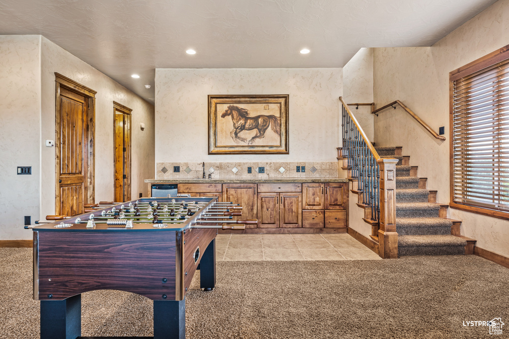 Recreation room featuring baseboards, light carpet, light tile patterned floors, and recessed lighting