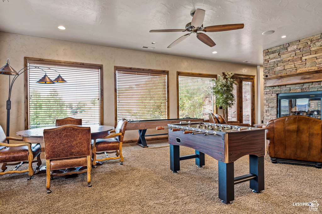 Playroom with carpet, a ceiling fan, recessed lighting, and a fireplace