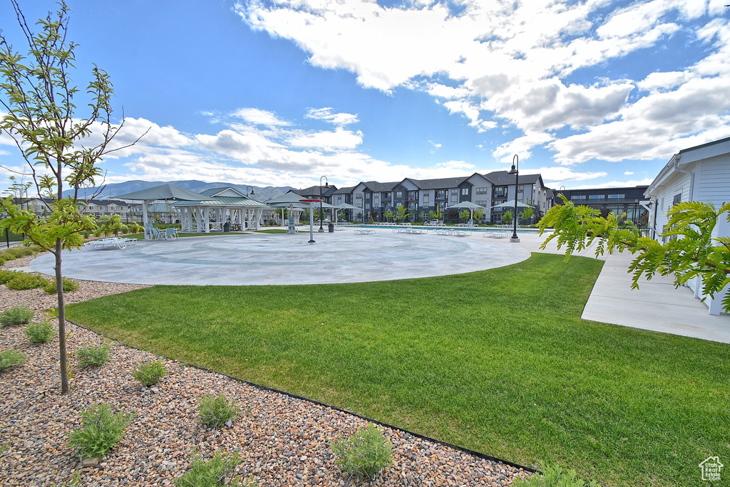 View of basketball court featuring a residential view, a lawn, and community basketball court