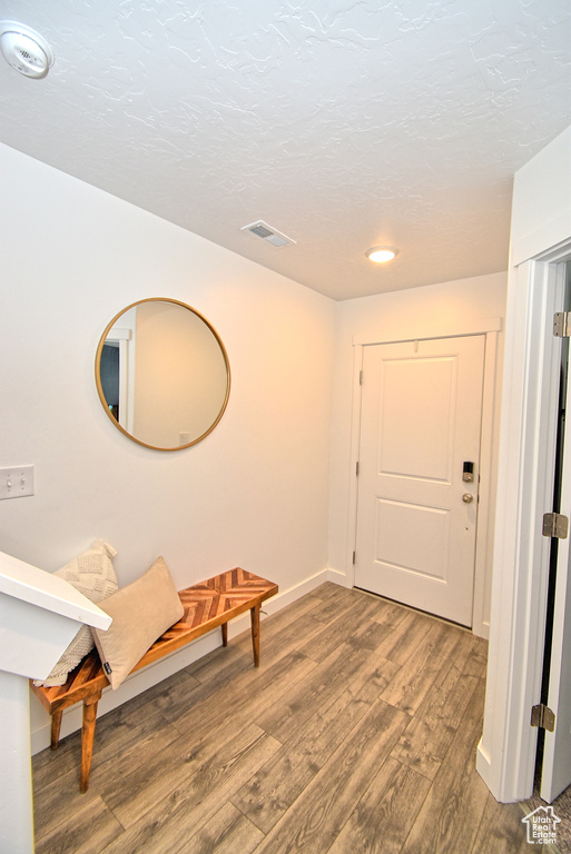 Foyer entrance with wood finished floors, baseboards, and recessed lighting