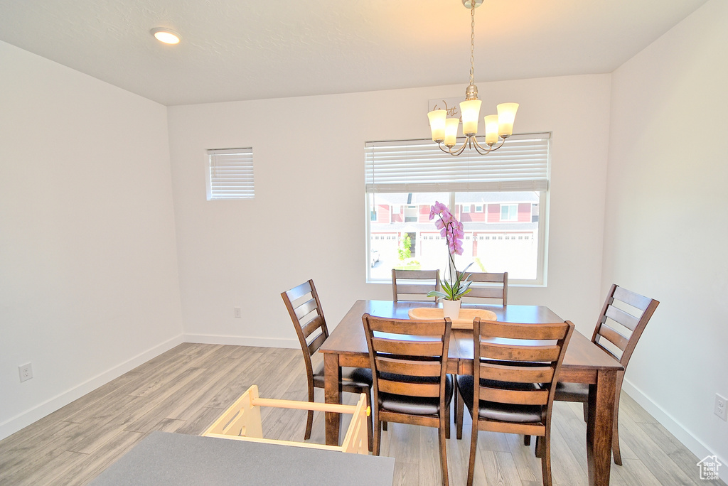 Dining space featuring a chandelier, light wood-style flooring, baseboards, and recessed lighting