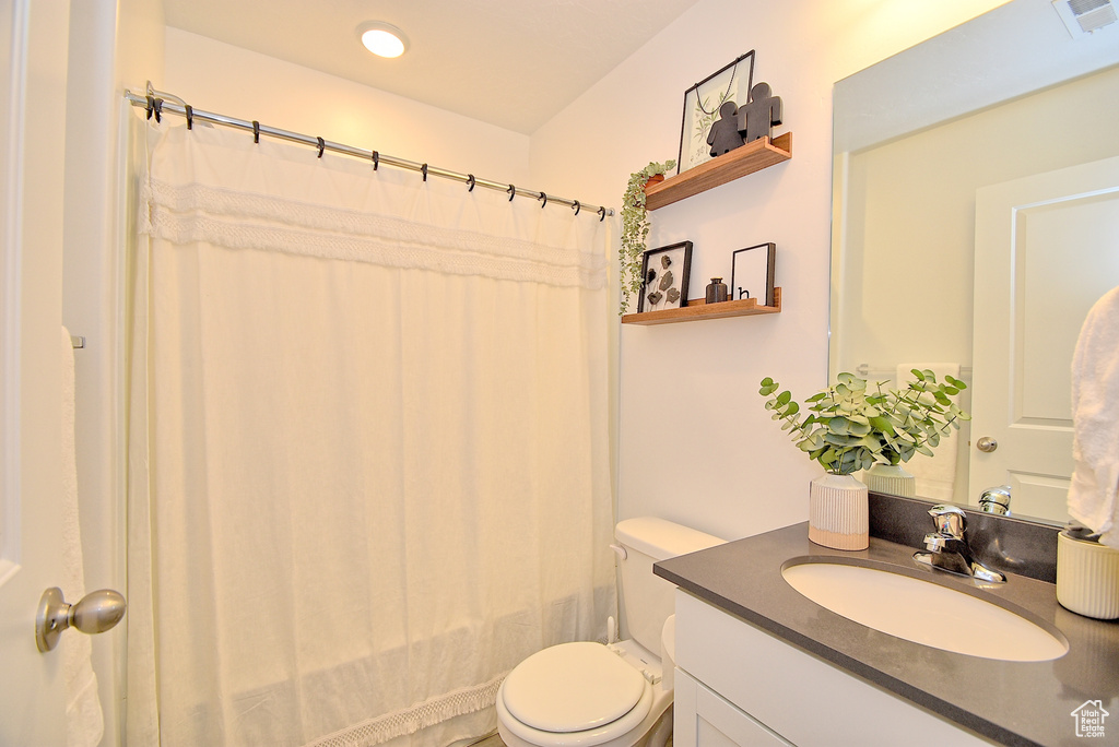 Full bathroom with toilet, vanity, shower / tub combo with curtain, and recessed lighting