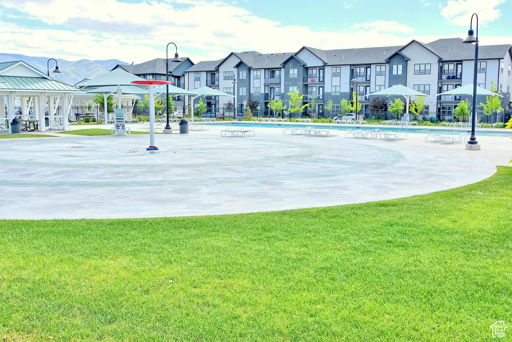 View of basketball court featuring a residential view, a yard, and a community pool