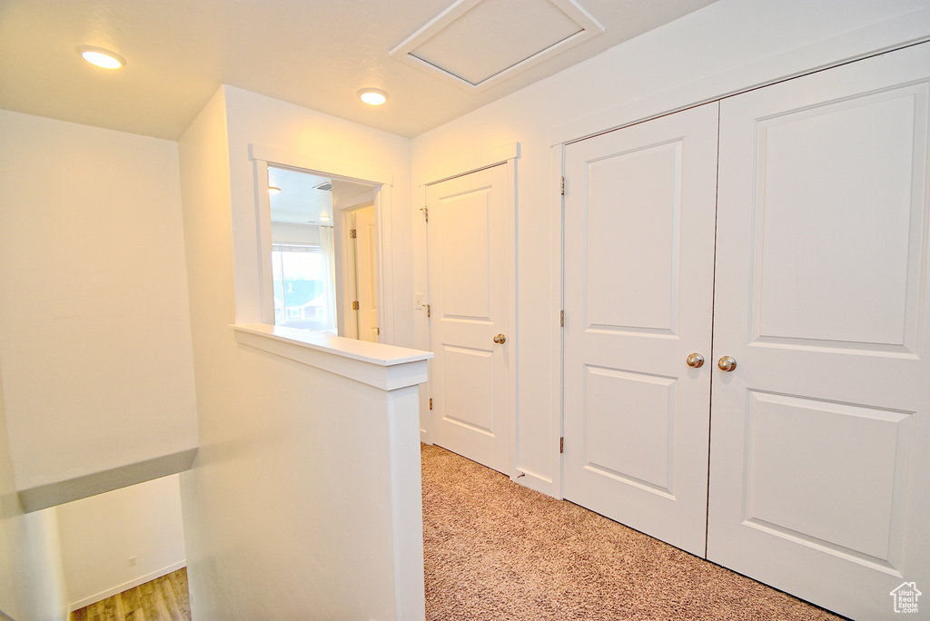 Hallway featuring recessed lighting, attic access, and light carpet