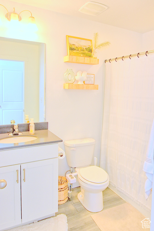 Bathroom with vanity, toilet, and wood finished floors