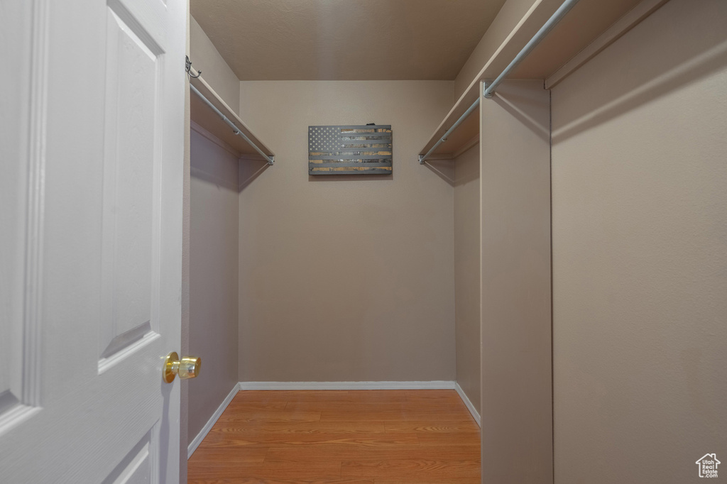 Walk in closet with light wood-style floors