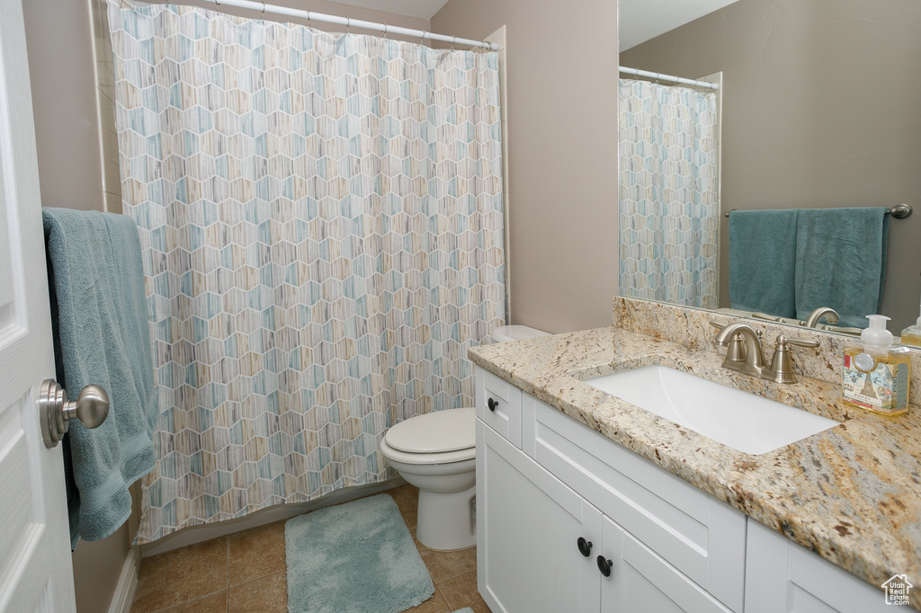Full bathroom featuring toilet, vanity, tile patterned flooring, and a shower with shower curtain