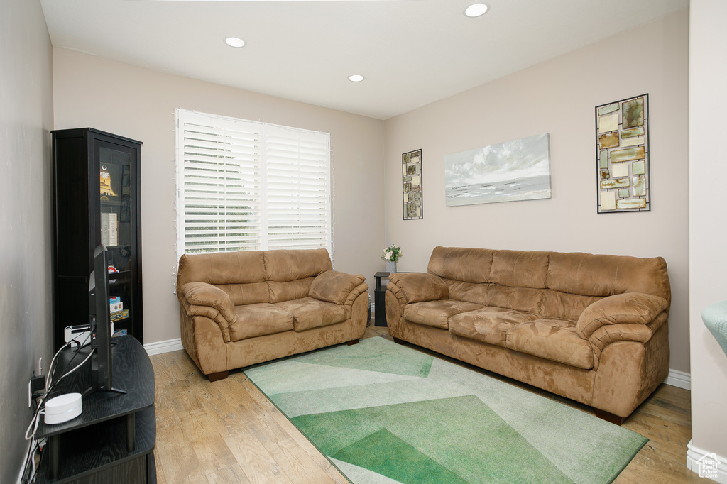 Living area with light wood-style floors, recessed lighting, and baseboards