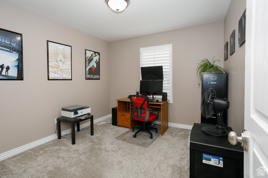 Office space with light colored carpet and baseboards