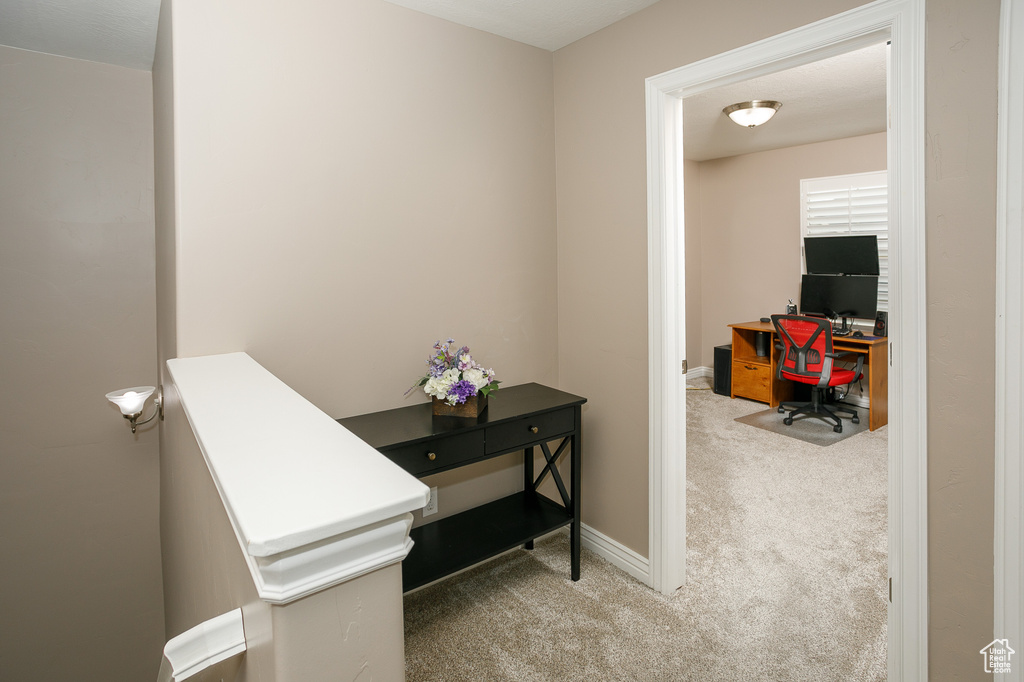 Hall featuring carpet, an office area, and baseboards