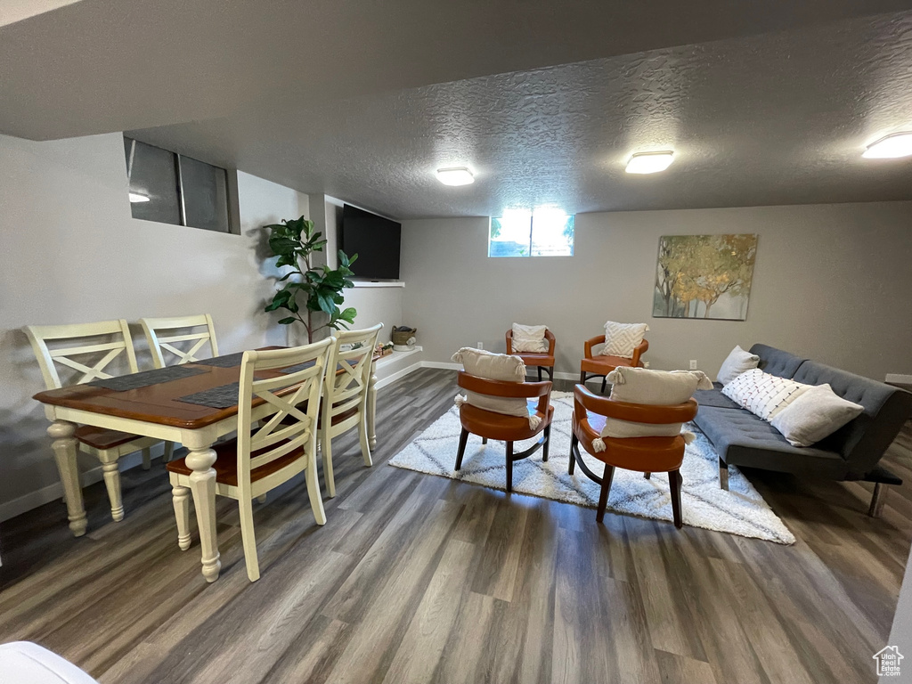 Living area featuring wood finished floors, a textured ceiling, and baseboards