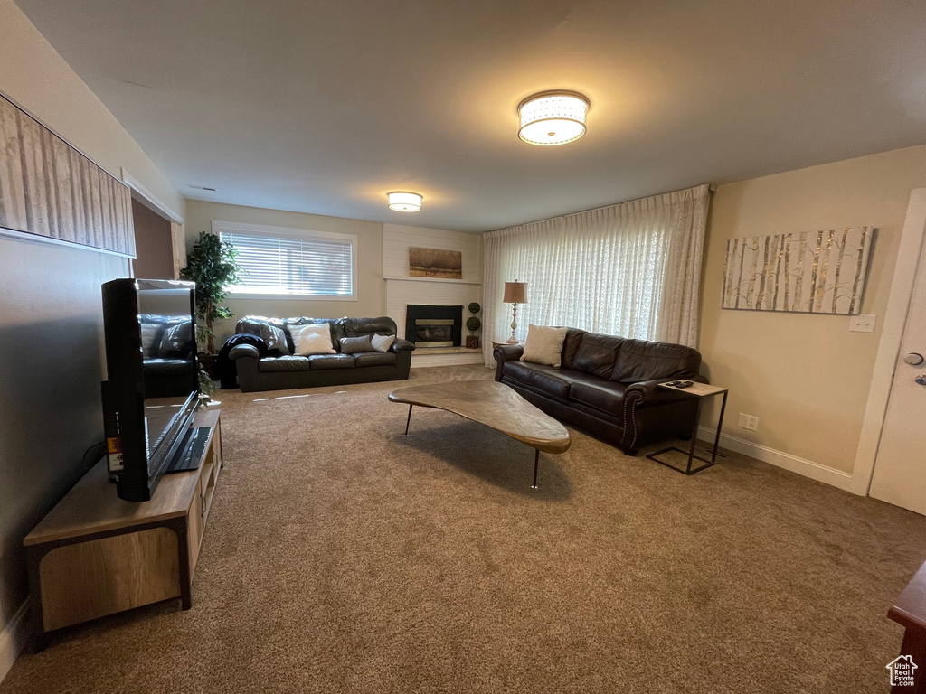 Living room with carpet and a large fireplace