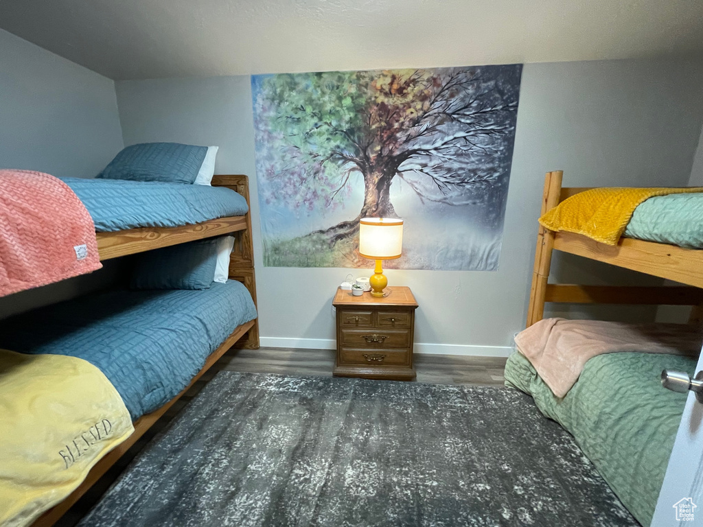 Bedroom with wood finished floors and baseboards