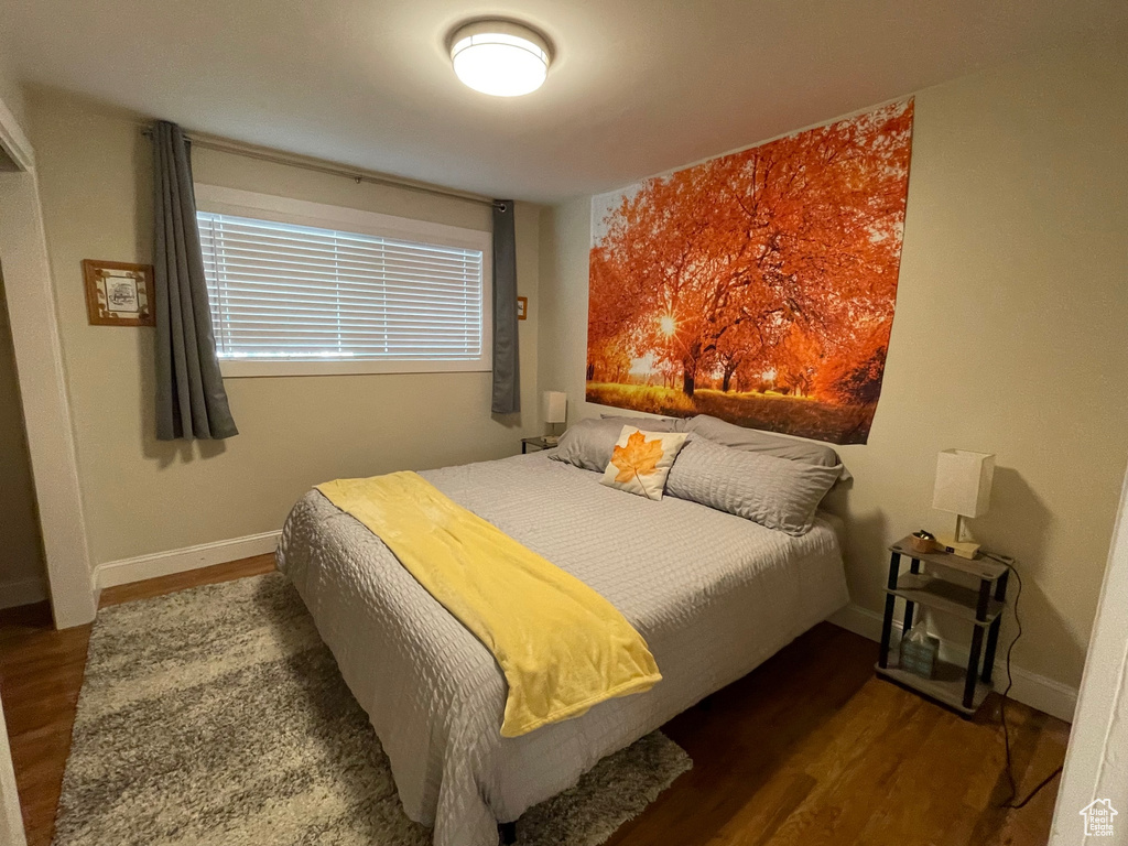 Bedroom with wood finished floors and baseboards