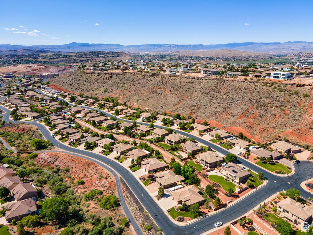 Aerial overview of property's location with a mountain backdrop and nearby suburban area