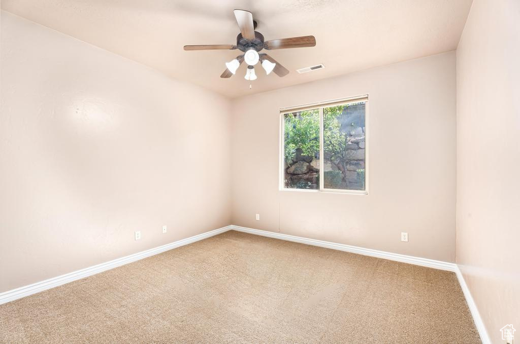Unfurnished room featuring carpet flooring, ceiling fan, and baseboards