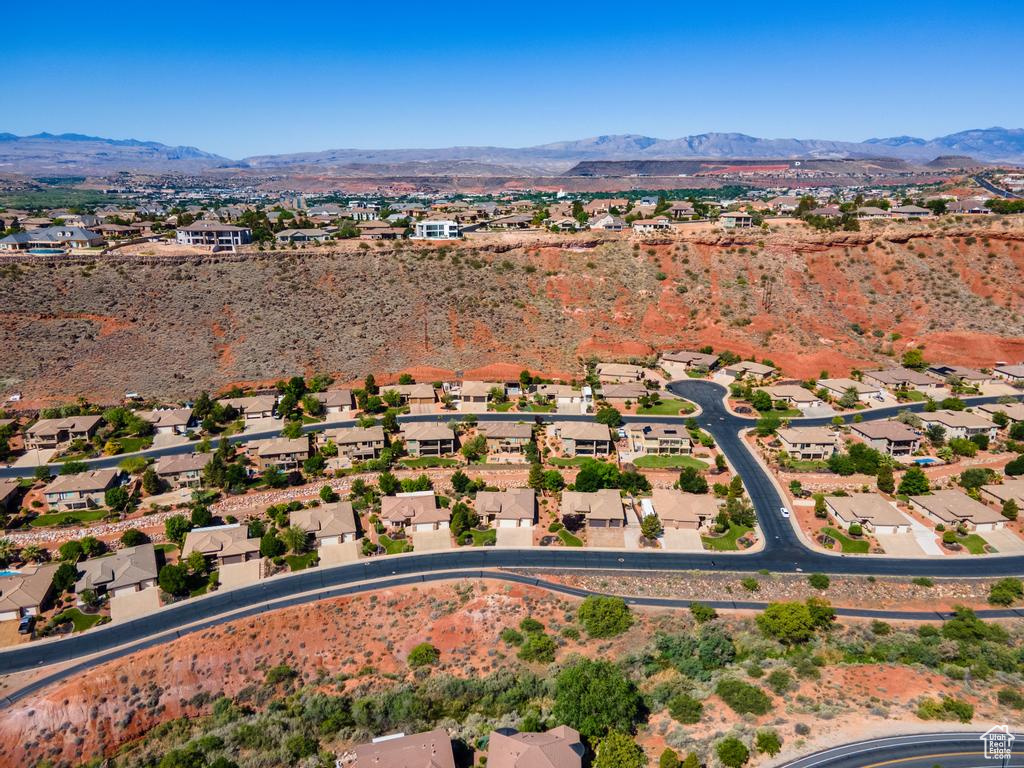 Aerial view of property and surrounding area featuring mountains and nearby suburban area