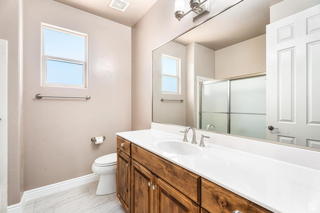Full bathroom featuring a stall shower, baseboards, toilet, vanity, and marble finish floors